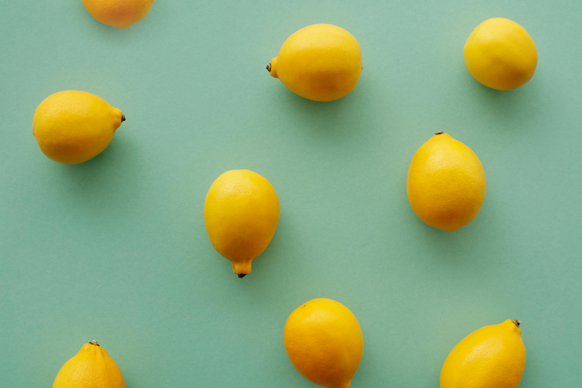 Bright yellow lemons arranged on a pastel background, representing fresh approaches to intimate pleasure
