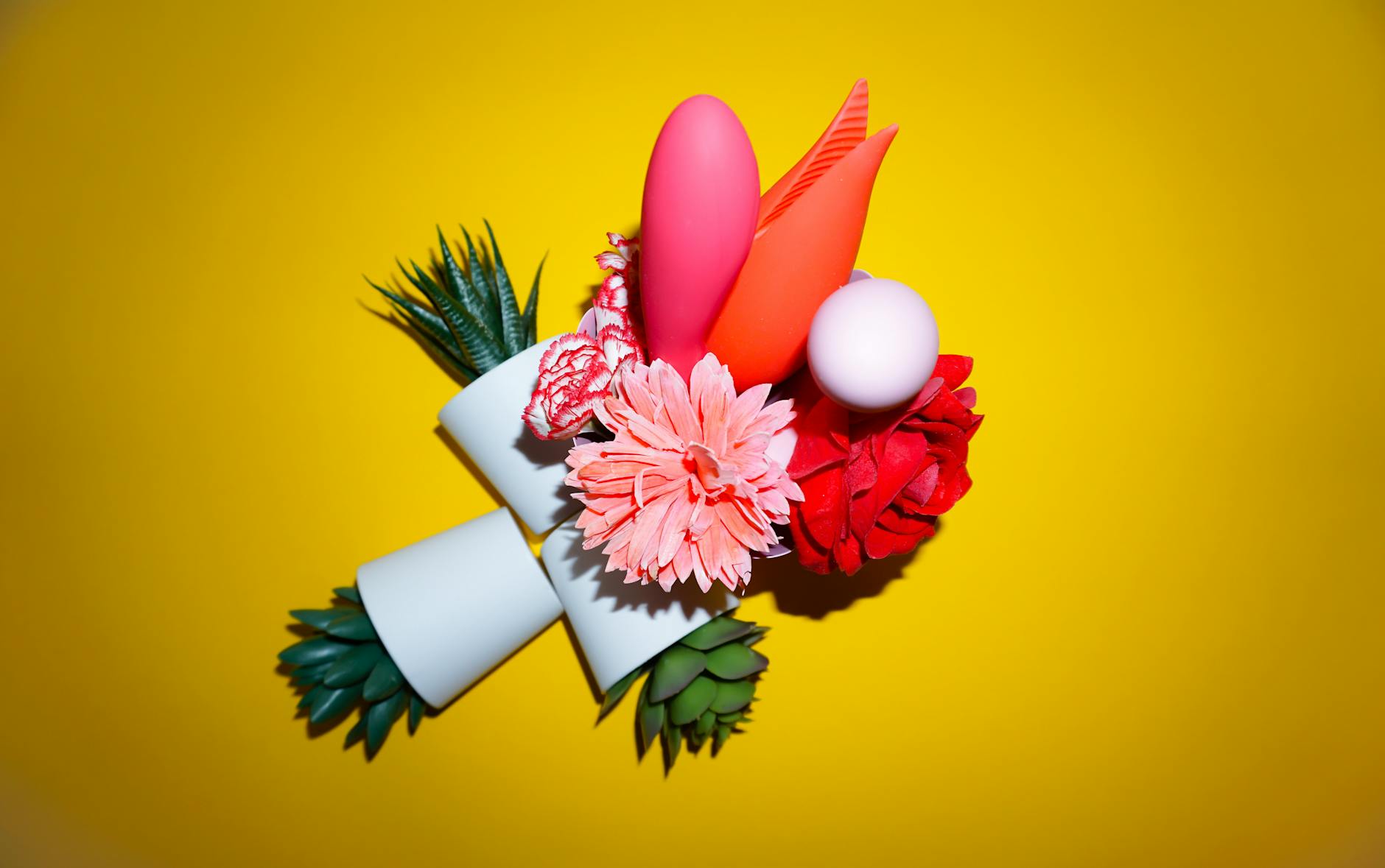 Colorful arrangement of lemon vibrators and flowers on a bright yellow background